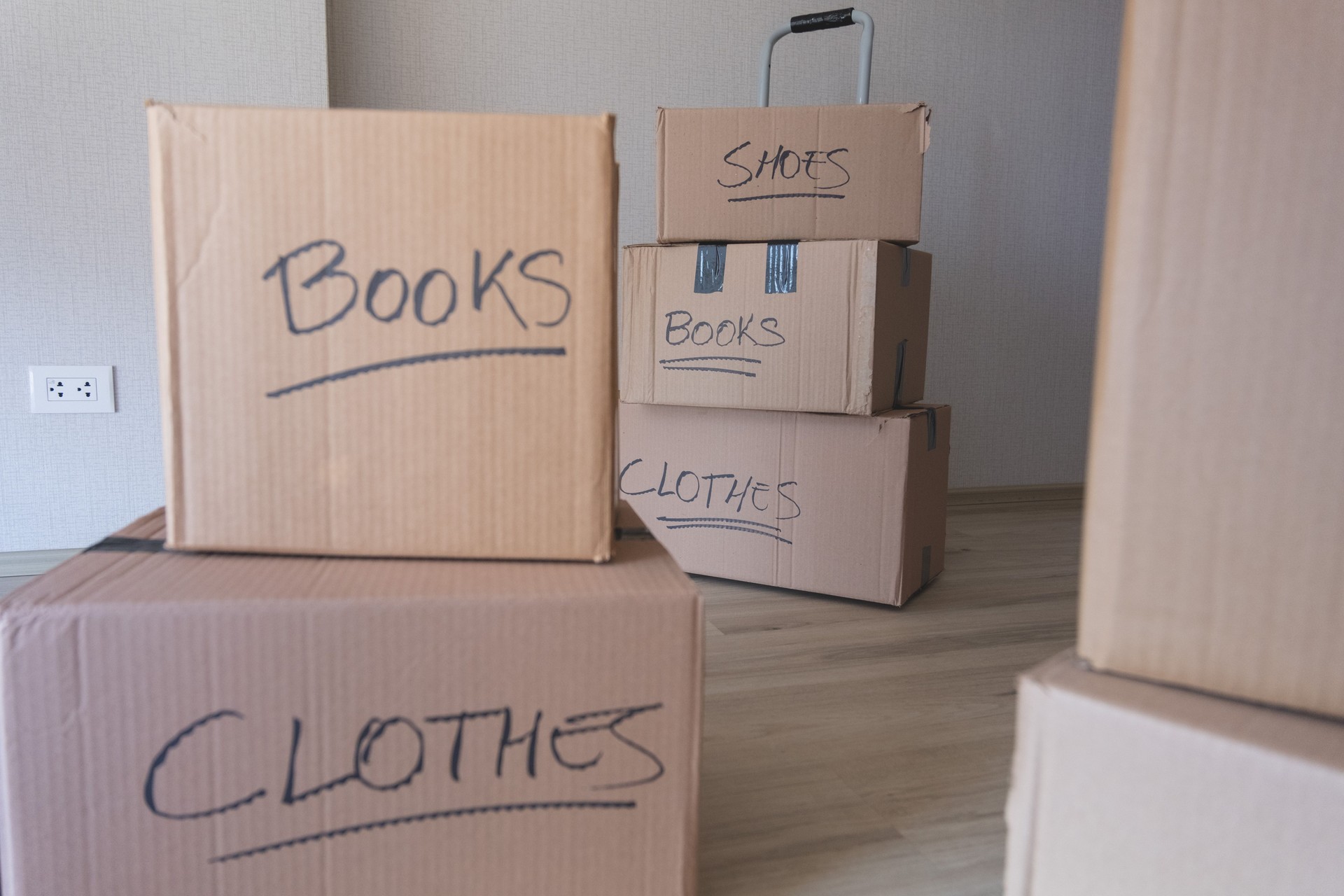 A stack of boxes with the words "books" and "clothes" written on them. New house concept.